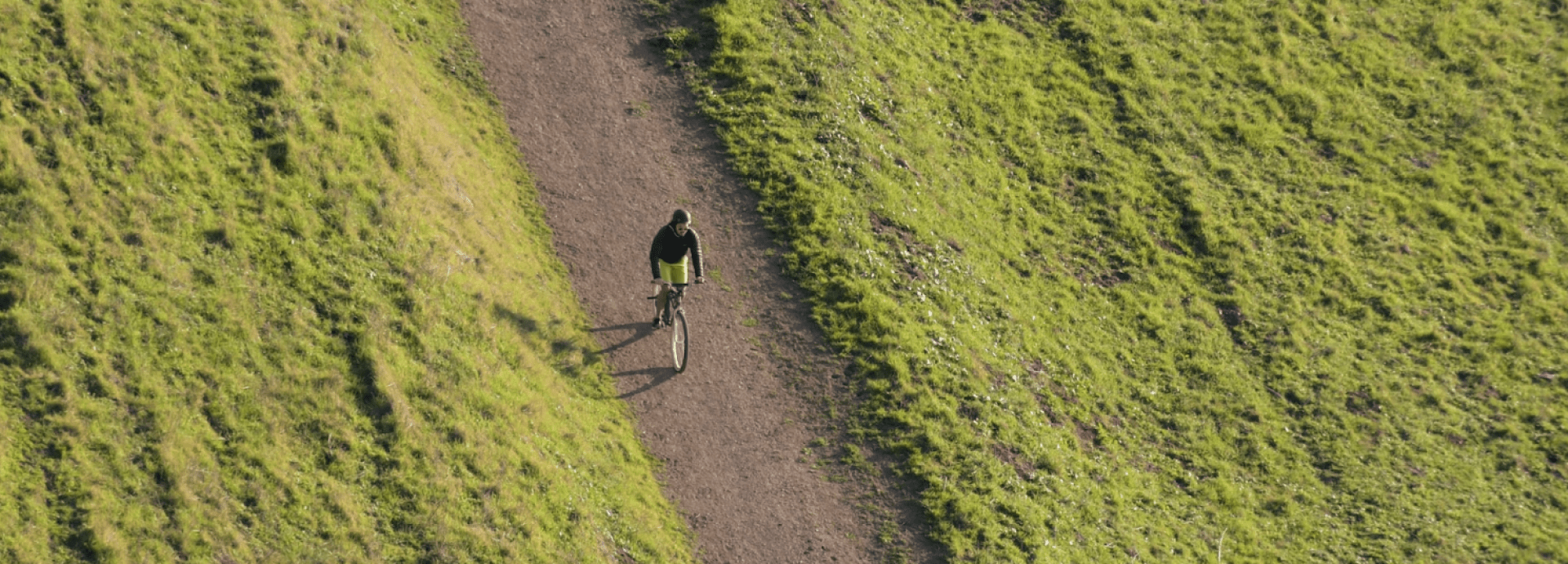 Een jongen op een fiets op een zandweg met links en rechts weiland
