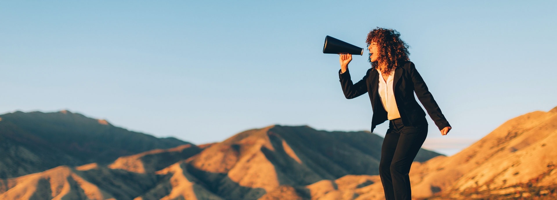 Zakenvrouw schreeuwt door een megaphone