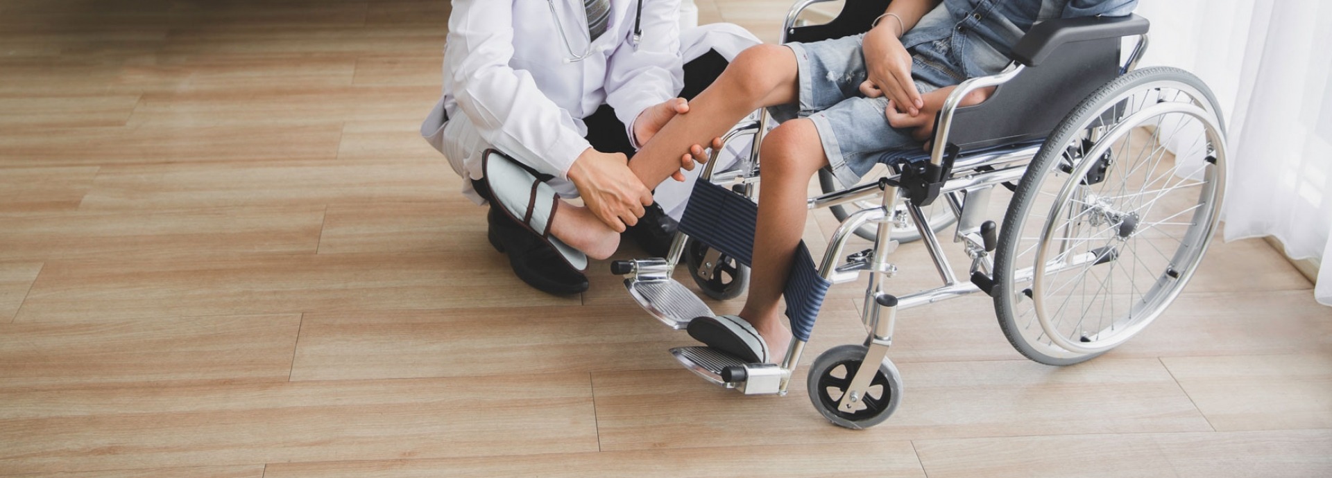 Arts die been van patiënt in rolstoel in het ziekenhuis controleert