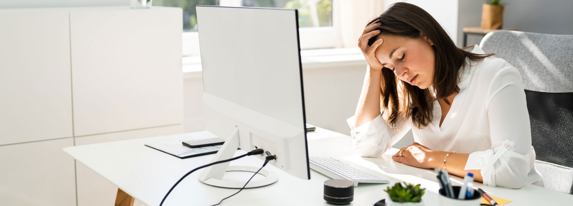 vrouw gestrest achter haar computer op het werk