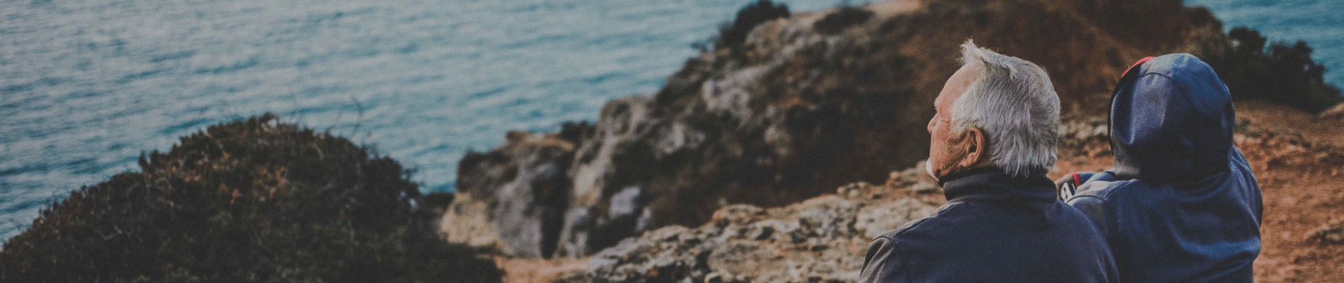 Een ouder stel zittend op een cliff bij de zee